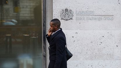 Man walking past the London Stock Exchange 