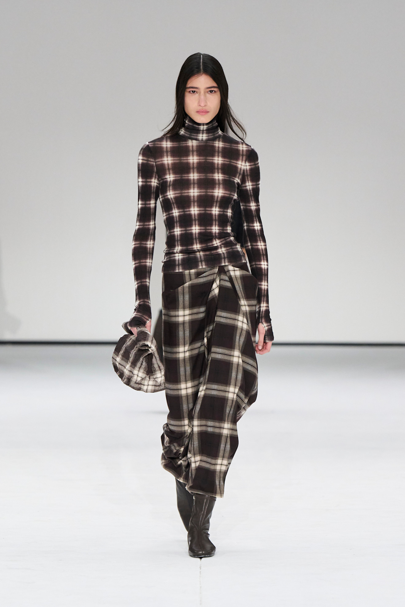 Photo of model on runway wearing checkered plaid maxi skirt.