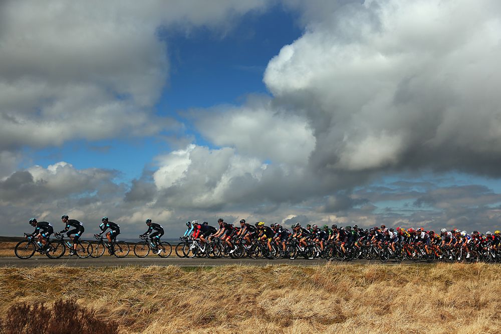 The clouds break to blue sky as the peloton races through stage 3