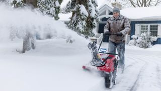 Man using snow blower in driveway