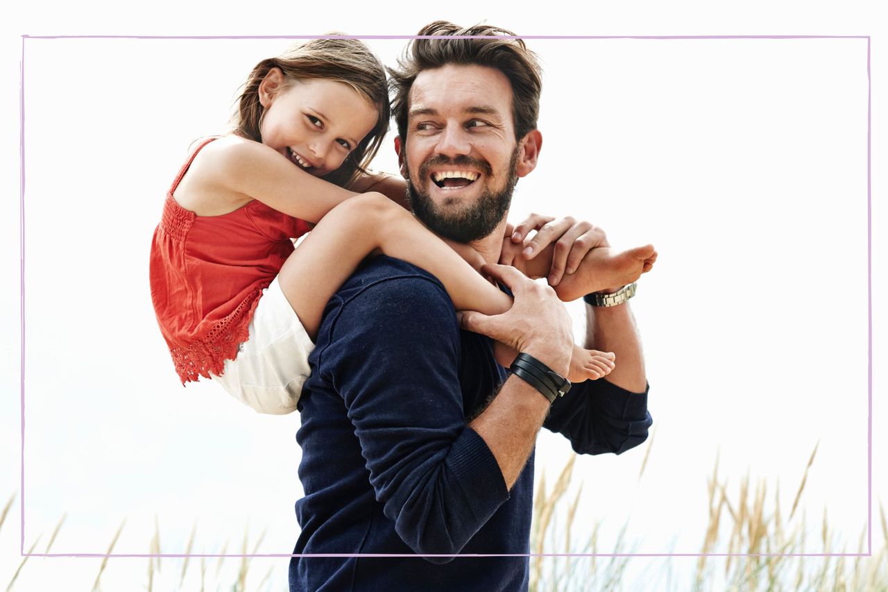 Smiling dad with daughter on his back