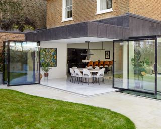 Home addition with dining table and chairs and bifold and pivot patio doors