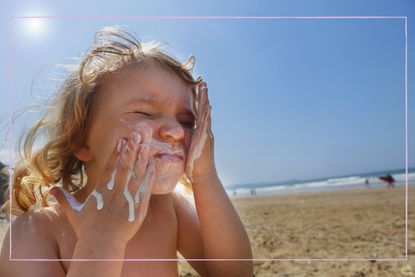 Child applying sun cream to their face