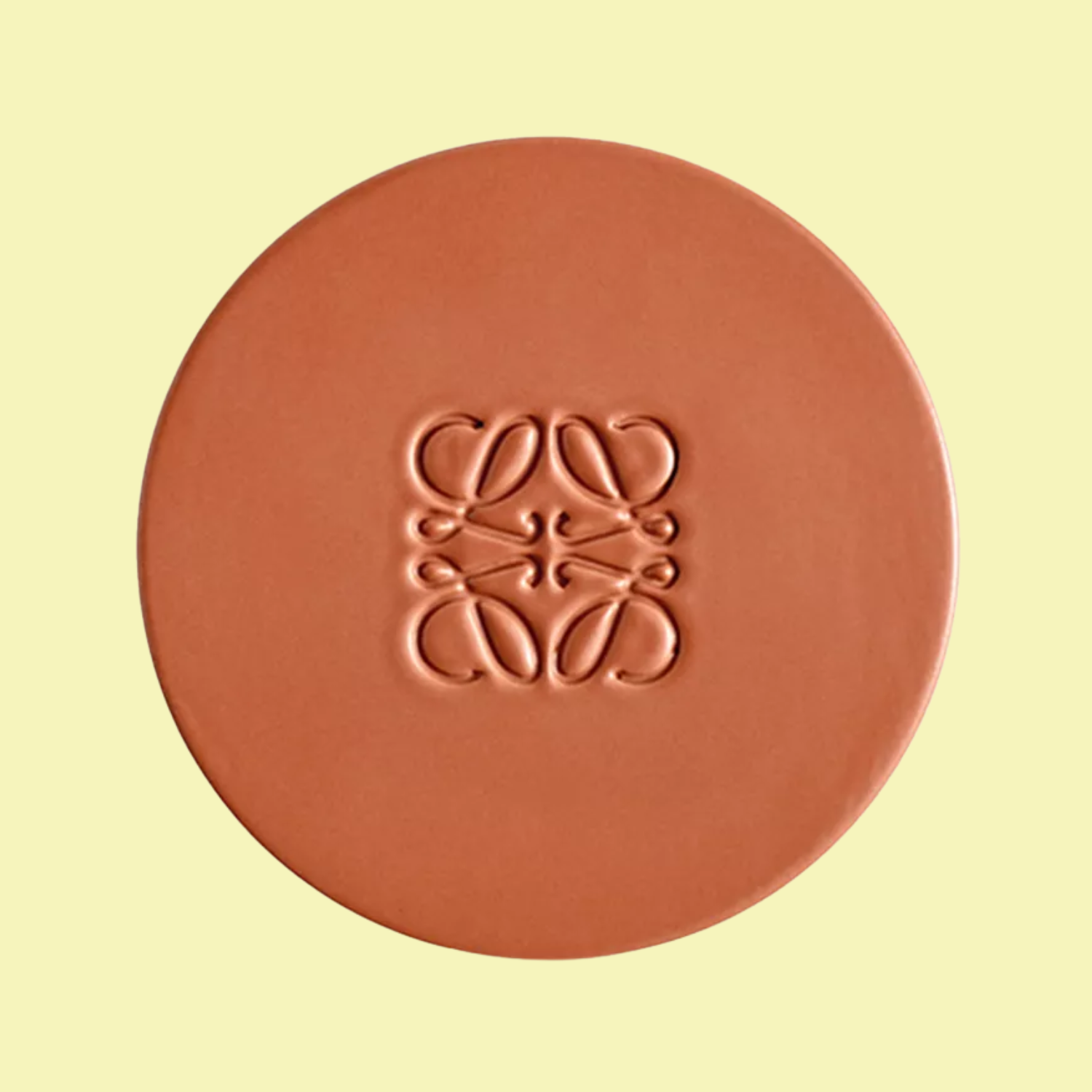 A tan Loewe-embossed candle cover