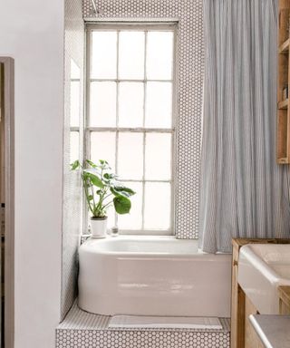 A tiled bathtub nook in a studio apartment