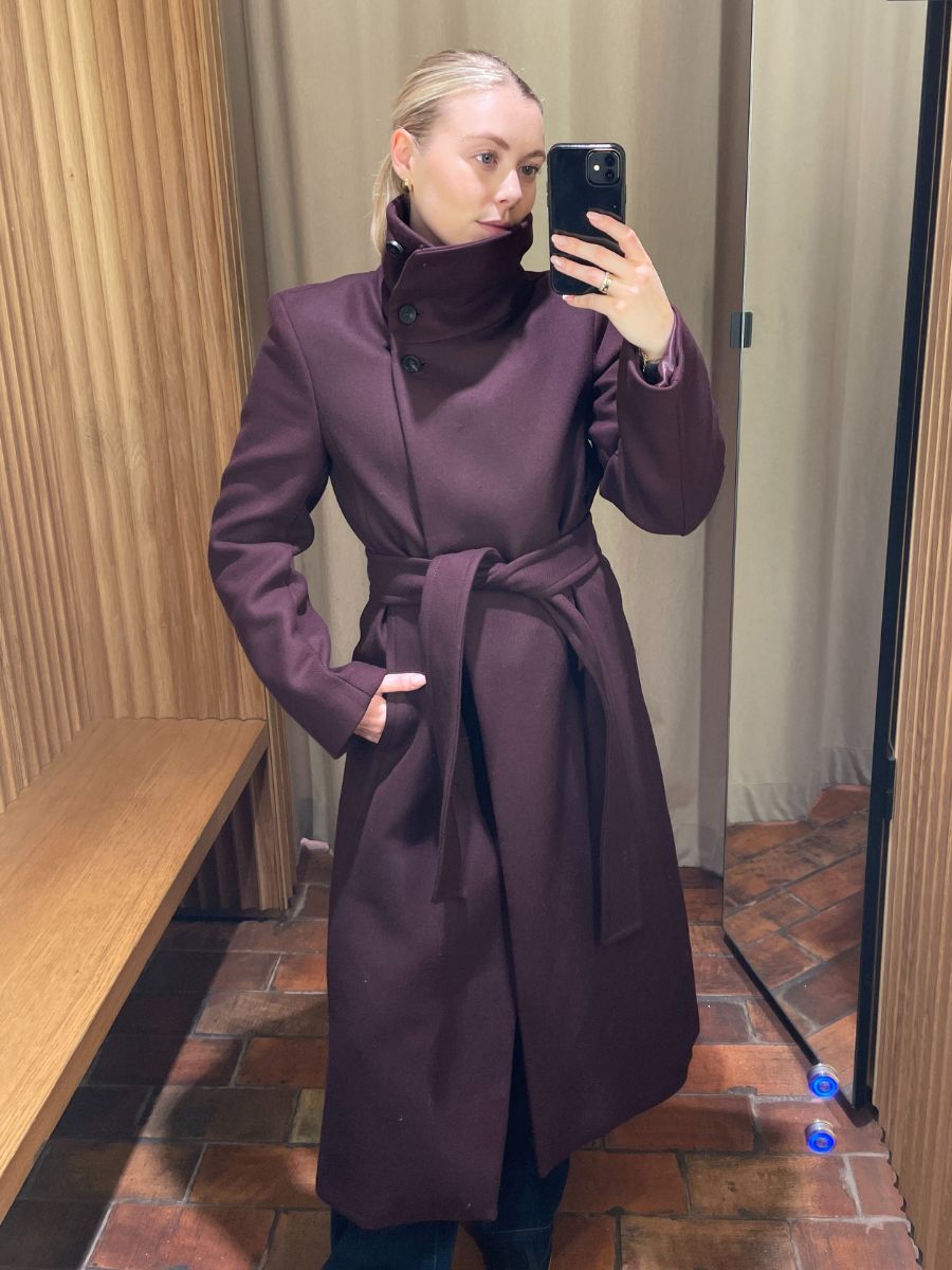 Woman wears burgundy coat