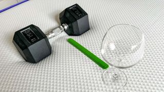 A weight, measuring tape and wine glass placed on the surface of the Nectar PRemier hybrid mattress