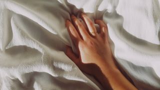Woman's hand touching a duvet