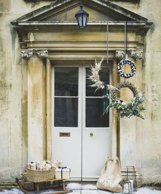 front door with festive cluster of wreaths hanging from different lengths