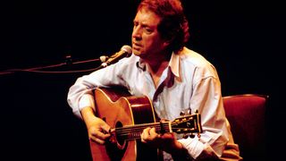 Photo of Bert JANSCH (1943-2011) performing live on stage at The Barbican in London in 1999.
