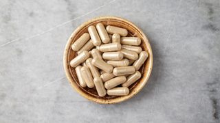 A bowl of ashwagandha capsules, one of the adaptogen foods