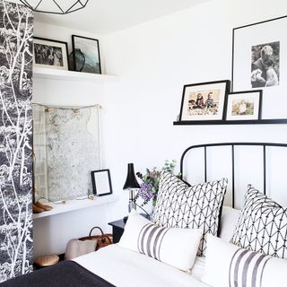 White bedroom with map on wall and black bed