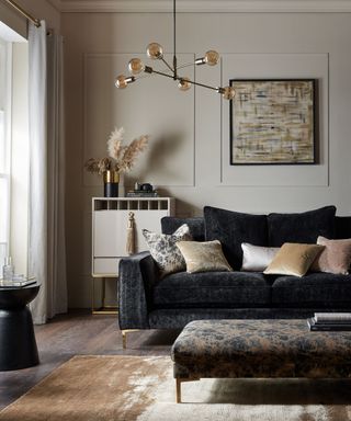 A luxe small living room with a black couch, coffee table, and wall decor