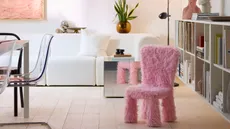A pink fluffy chair in a neutral living room