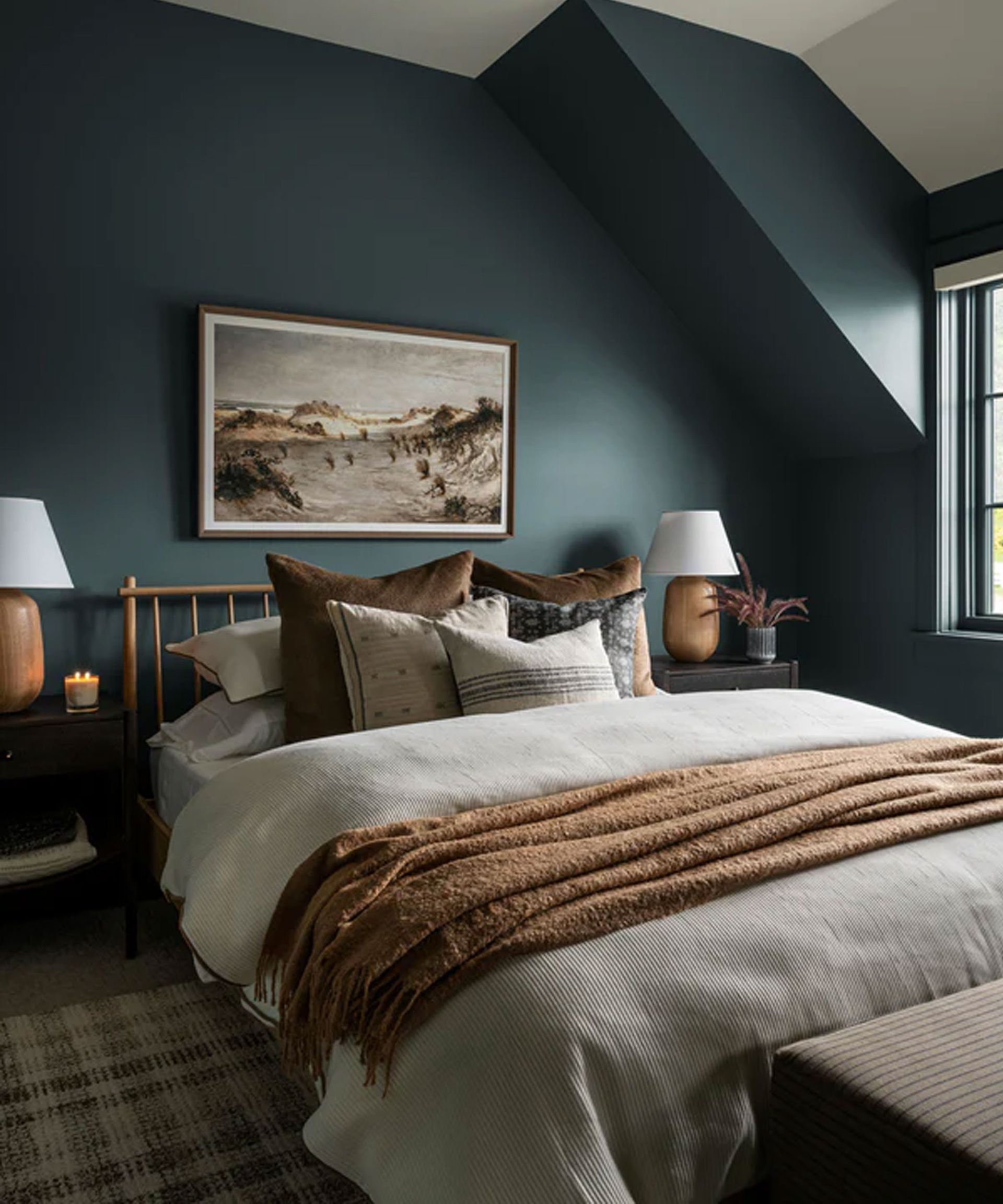 Blue bedroom with bed, artwork on wall