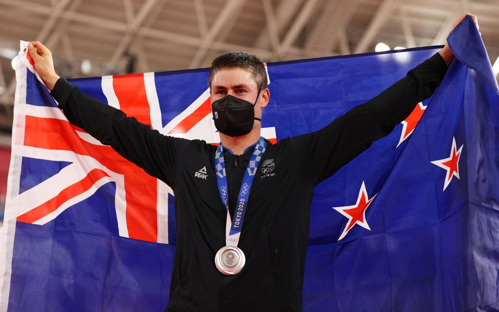 IZU JAPAN AUGUST 05 Silver medalist Campbell Stewart of Team New Zealand pose on the podium while holding the flag of his country during the medal ceremony after the Mens Omnium final of the track cycling on day thirteen of the Tokyo 2020 Olympic Games at Izu Velodrome on August 05 2021 in Izu Japan Photo by Justin SetterfieldGetty Images