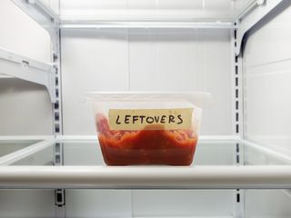 A plastic box of leftover food in the fridge.