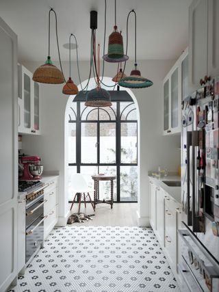 Small white galley kitchen with black and white penny tiles