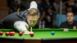 Judd Trump lines up a shot on a red