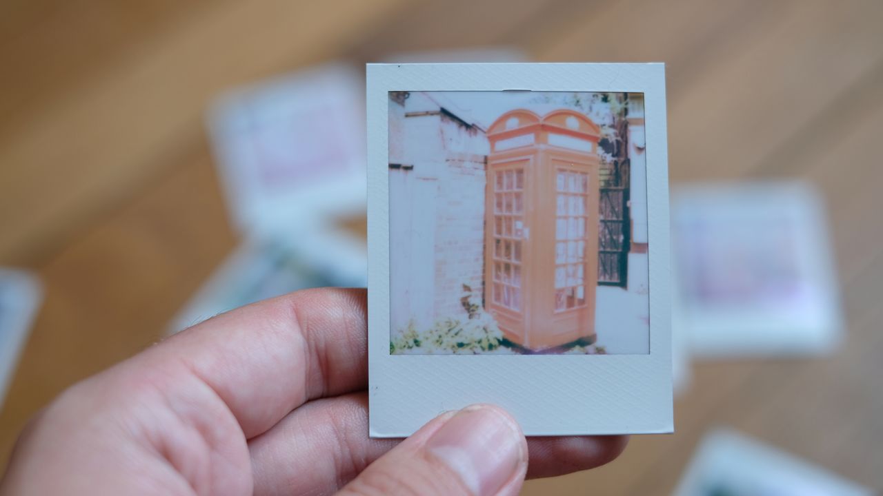 Photograph of prints made with Polaroid Go Gen 3 showing an overexposed red phone box