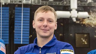 closeup of a smiling young man wearing a blue flight suit