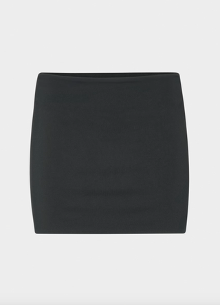 a black skirt from Aritzia in front of a plain backdrop