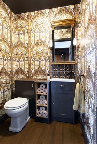cloakroom with classical gold architectural print wallpaper and narrow blue vanity unit with mirror above