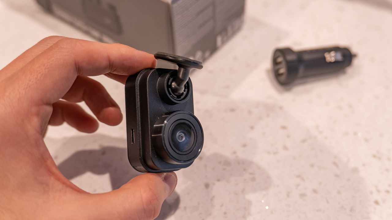 A hand holding the Garmin Dash Cam Mini 2