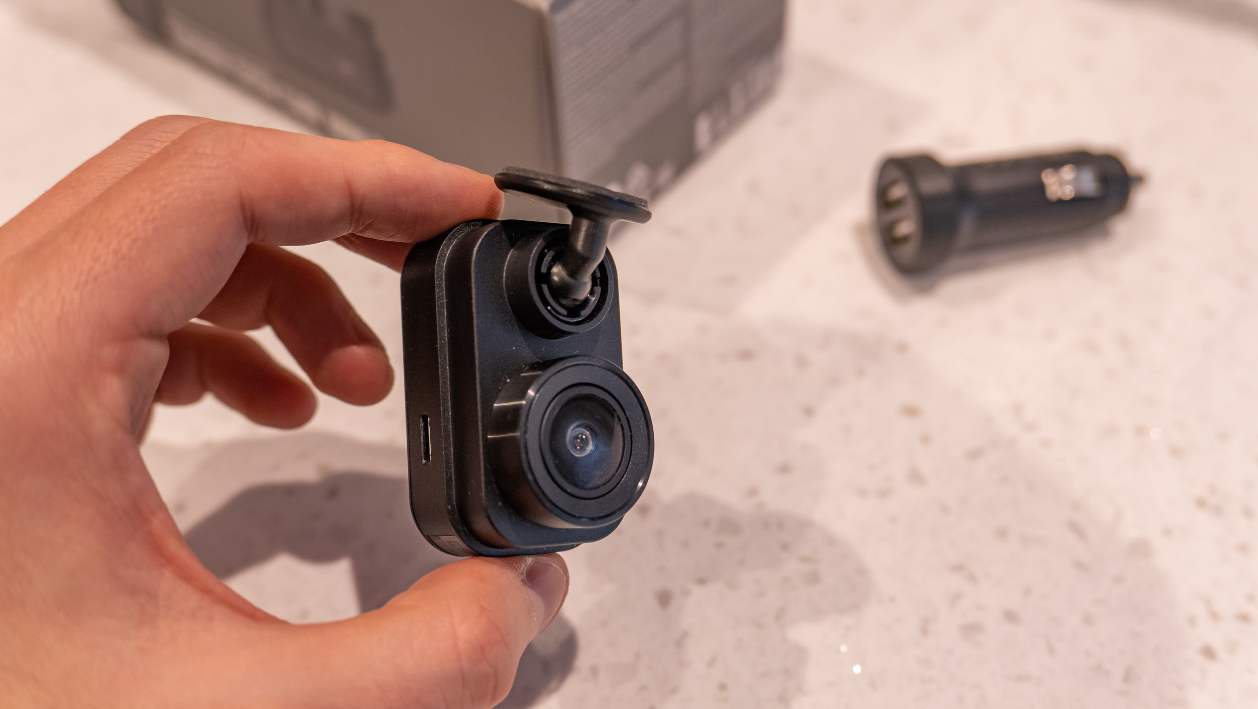 A hand holding the Garmin Dash Cam Mini 2