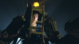 Sigourney Weaver as Ripley in a yellow robot during the movie Aliens.