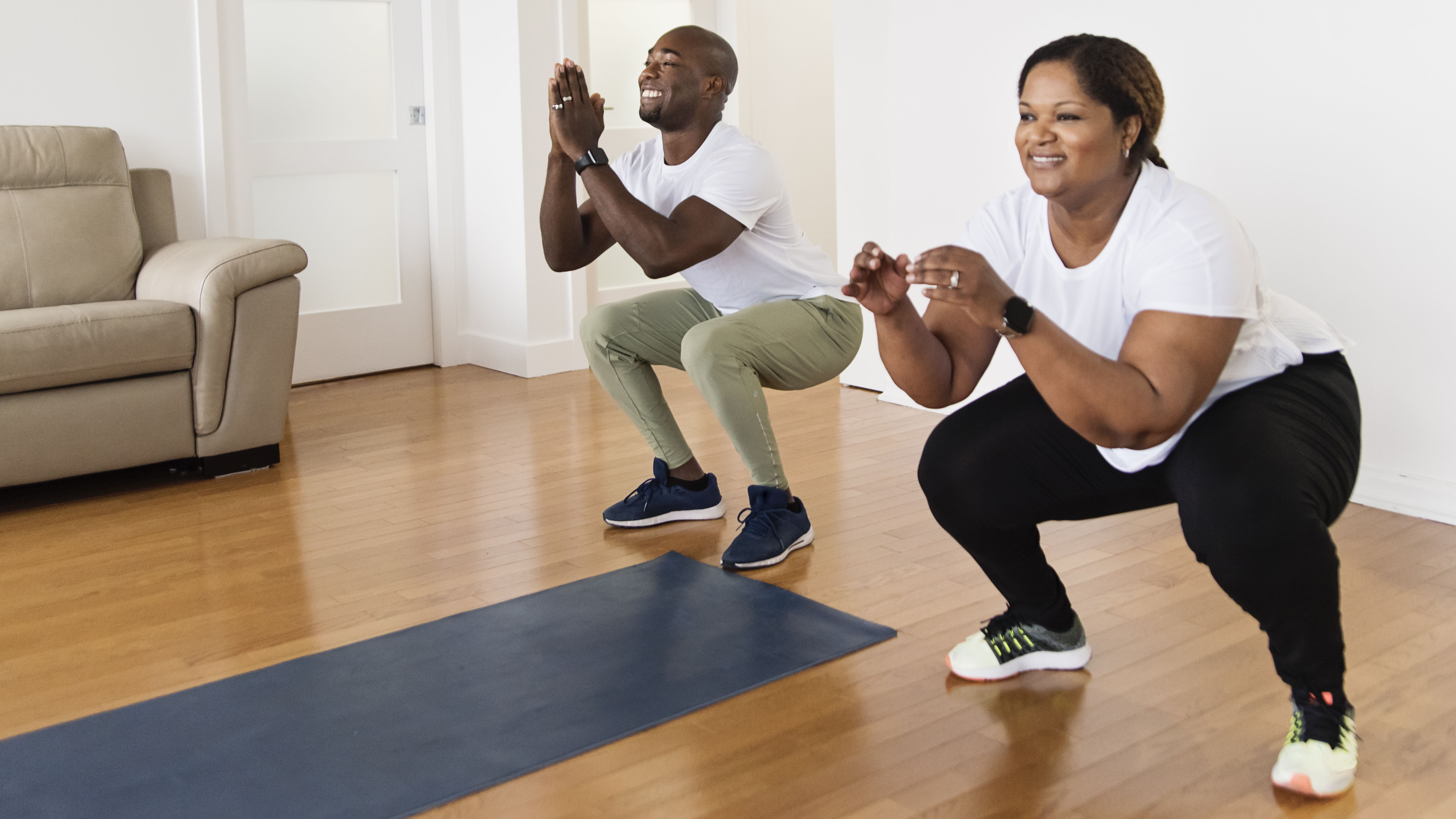 The couple performs a bodyweight squat to activate the gluteal muscles