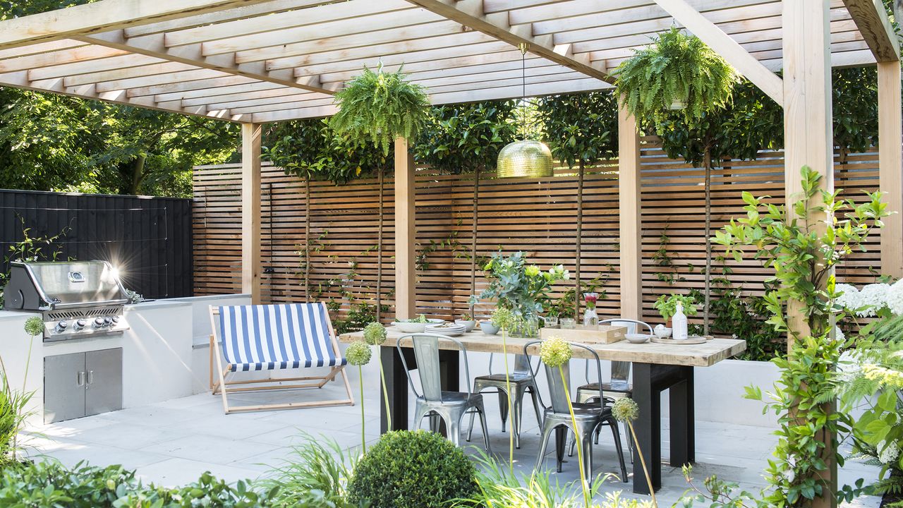 Outdoor dining area with wooden slat fence and pergola