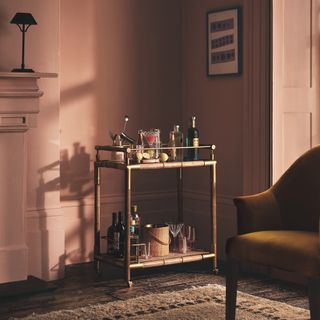 Bar cart with brass details in pink living room