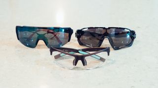 Three pairs of sunglasses on a marble countertop