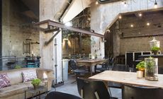 Exposed cement with structural steel , tables, hairs and couches