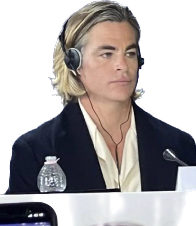 Chris Pine seated wearing a headset at the Don't Worry Darling press tour, without the original background, now on a white background