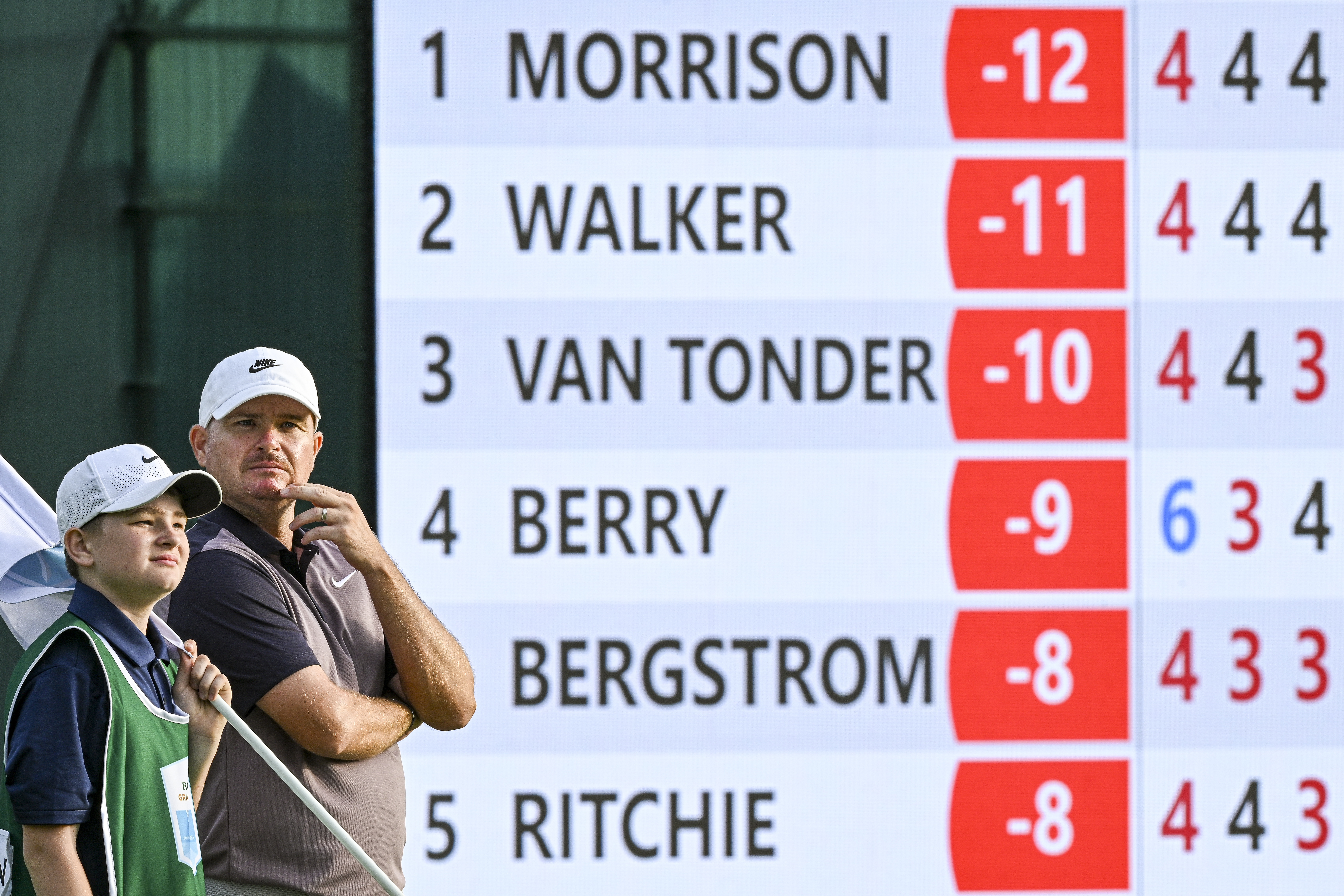 James Morrison and his son stand in front of a leaderboard