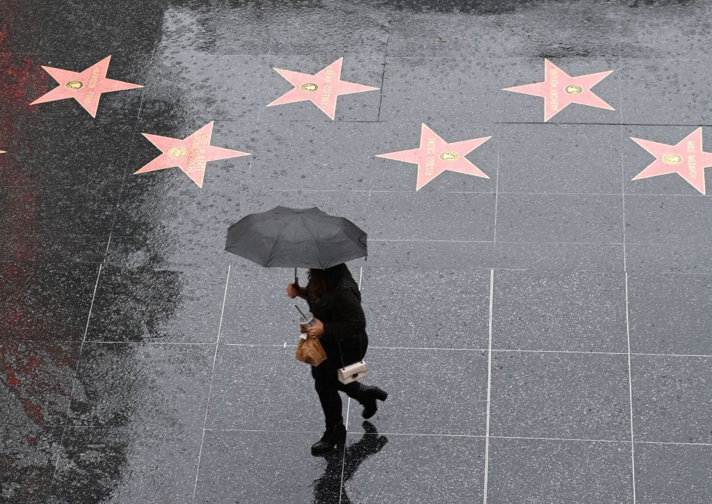 A person walks in the rain on Hollywood Boulevard.