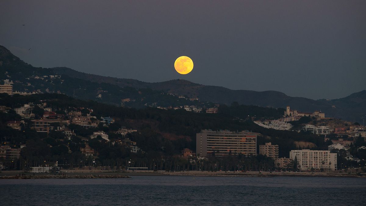 The Full Wolf Moon rises over the horizon at the beach in Malaga, Spain, on Jan. 10, 2020, during the first lunar eclipse of the year.