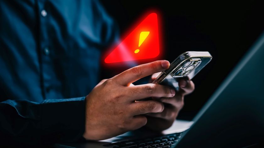 Man holding a mobile phone with warning notification and spam message icon