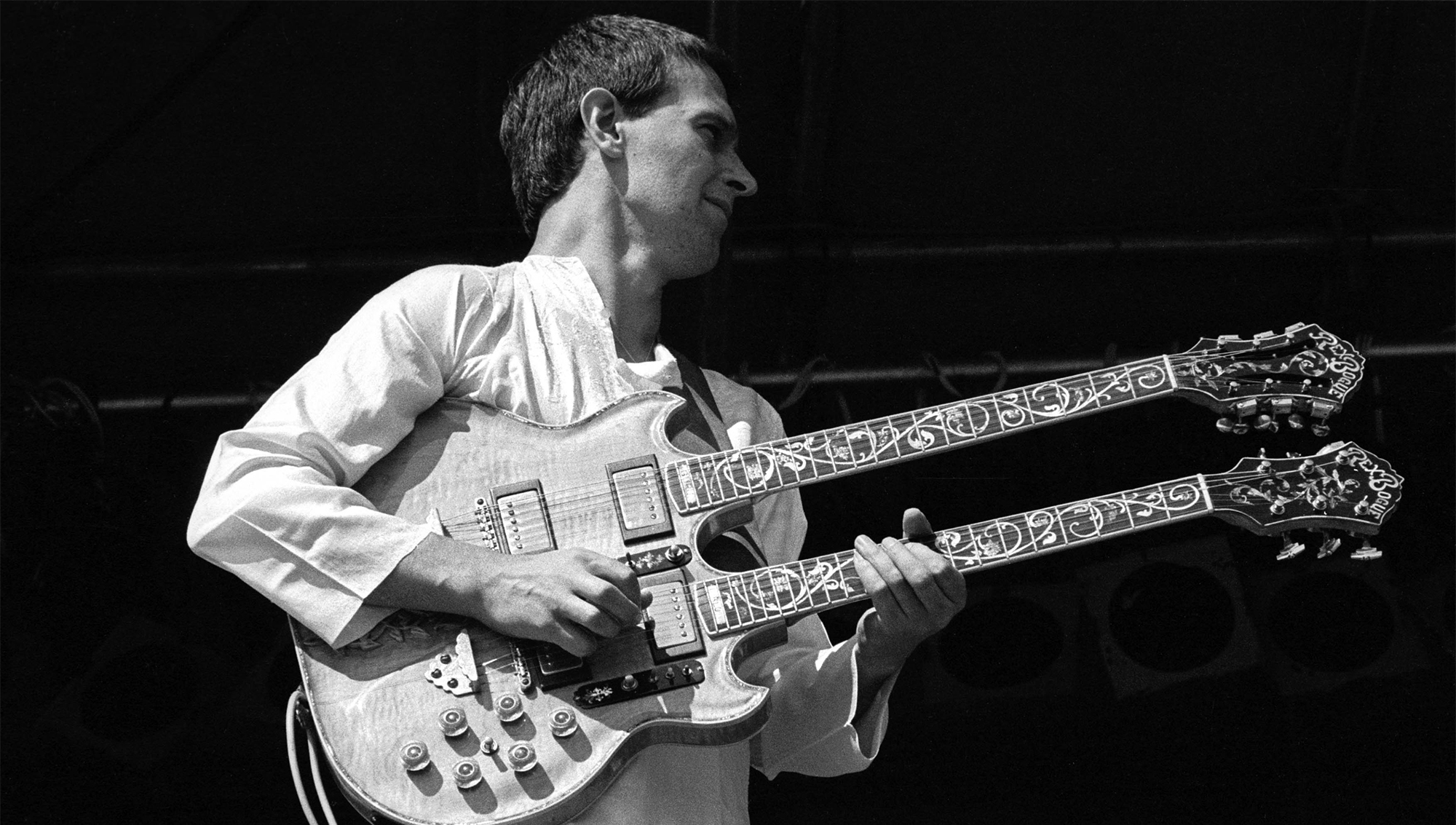 John McLaughlin performing on stage with Mahavishnu Orchestra and playing his Gibson EDS-1275 double-neck at Knebworth Festival, Knebworth House, Hertfordshire, 20 July 1974.