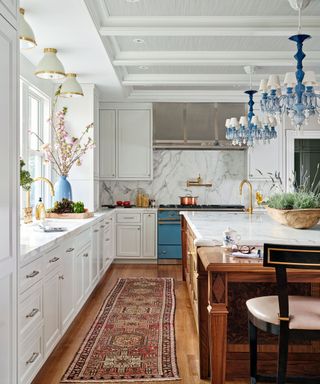 large kitchen with white cabinets and grey marble