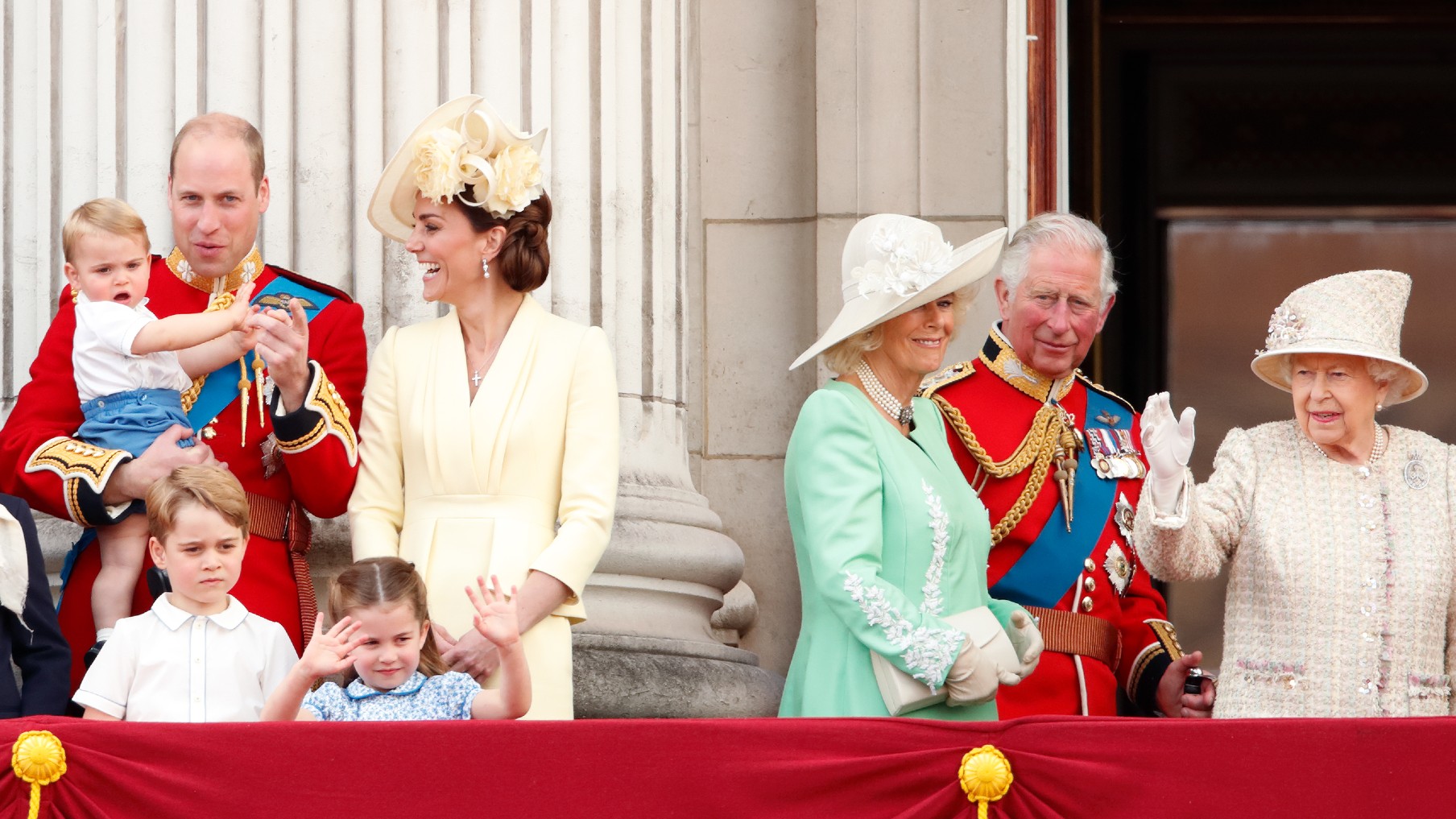 Princ William, vévoda z Cambridge, Catherine, vévodkyně z Cambridge, princ Louis z Cambridge, princ George z Cambridge, princezna Charlotte z Cambridge, Camilla, vévodkyně z Cornwallu, princ Charles, princ z Walesu a královna Alžběta II sledují z balkónu průlet Buckinghamského paláce