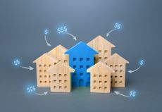 group of wooden houses with dollar signs above them