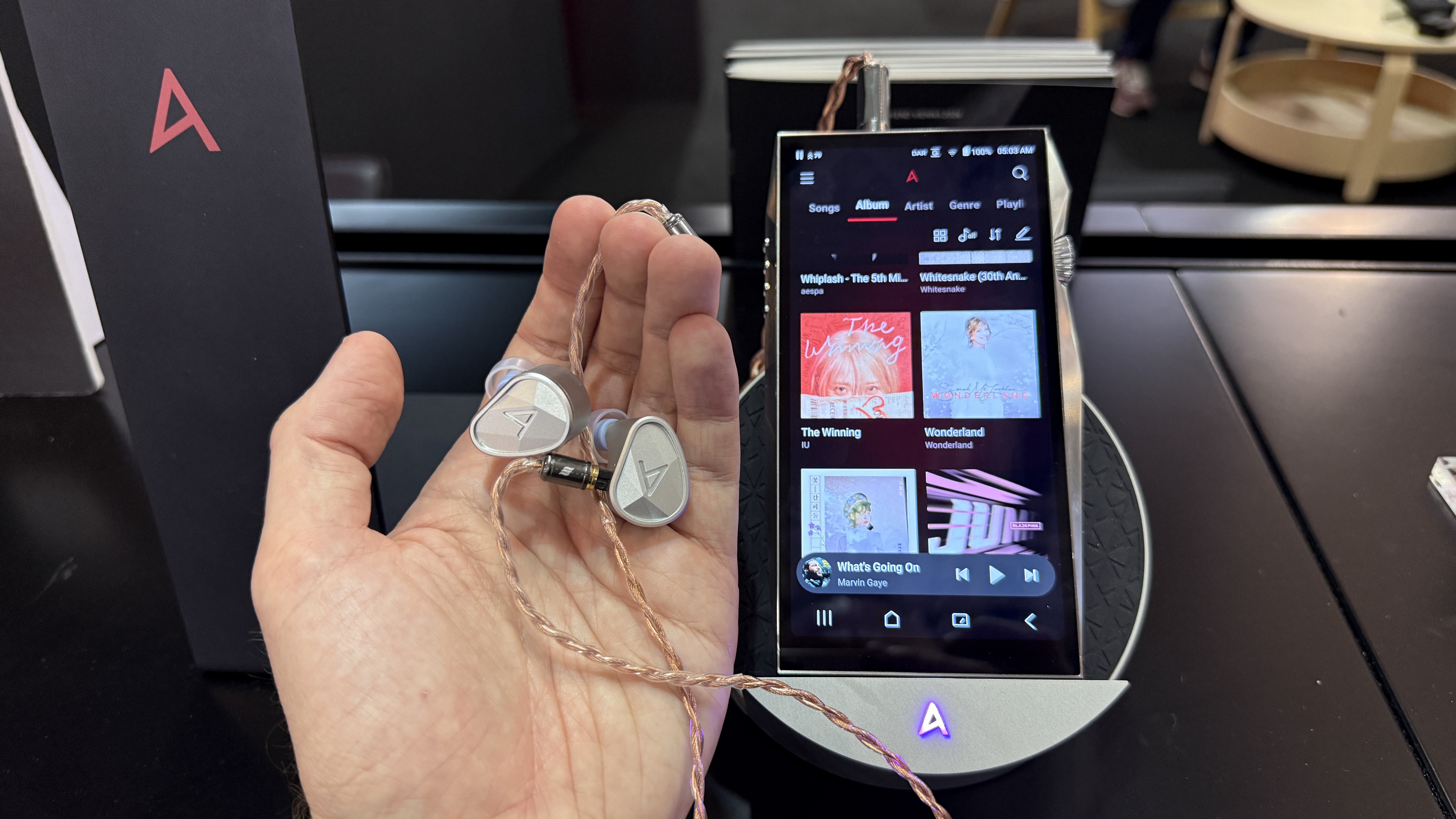 The Astell &amp;amp; Kern SP4000T player and Clarus earbuds, the earbuds are held in a man's hand