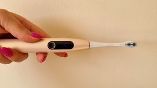 The Oclean X Pro Digital S electric toothbrush on a cream background