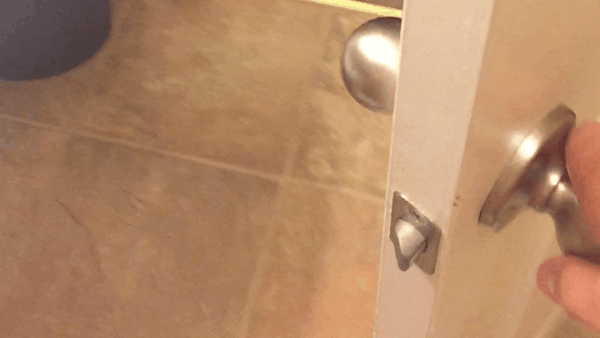 a door is blocked from closing because the corner of a bathroom sink is in the way.