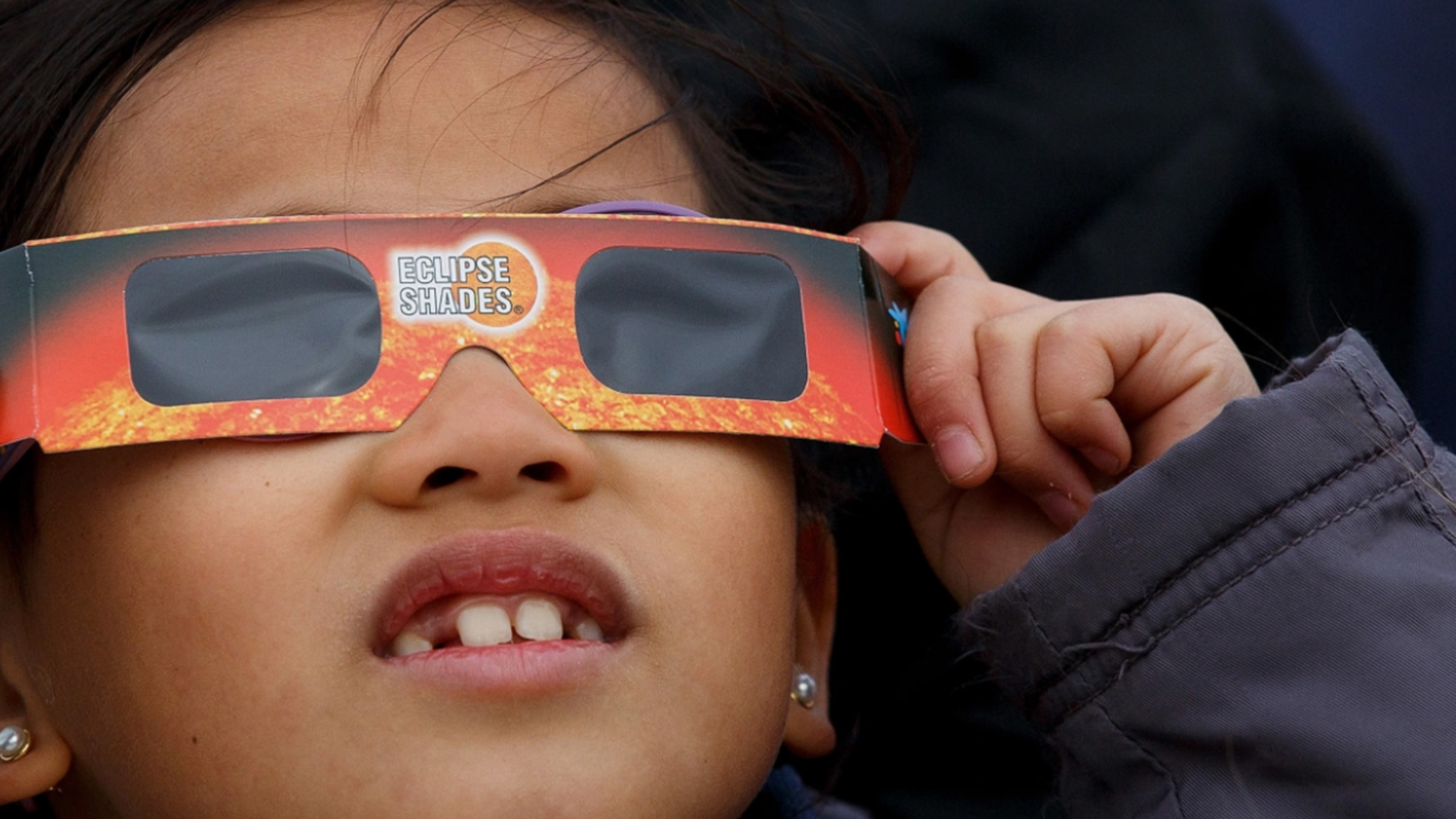 Young girl using solar glasses during an eclipse