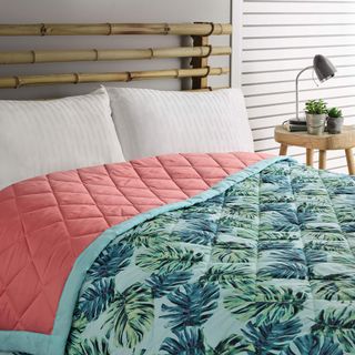 bedroom with flamingo cushions and tropical print bedding