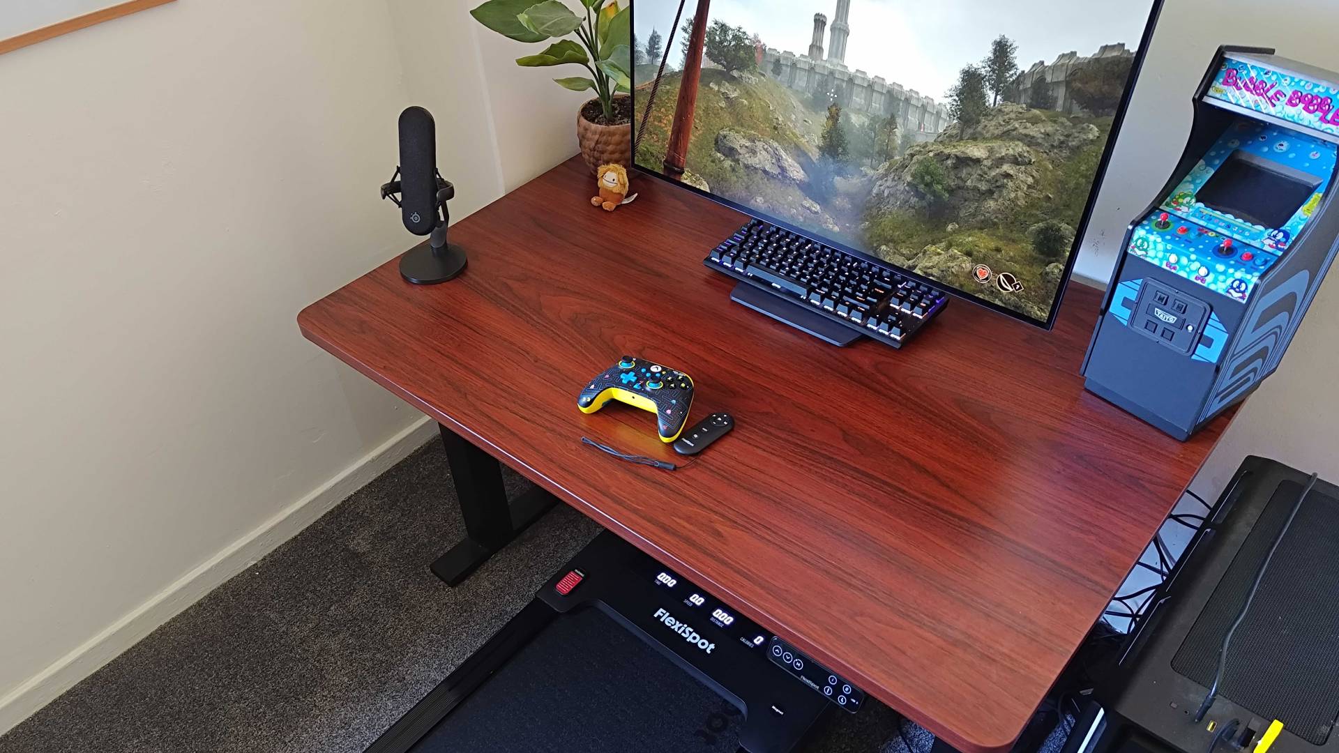 Angled view of Flexispot Under Desk Treadmill next to E7 Plus desk with Oblivion Remastered running on gaming PC.